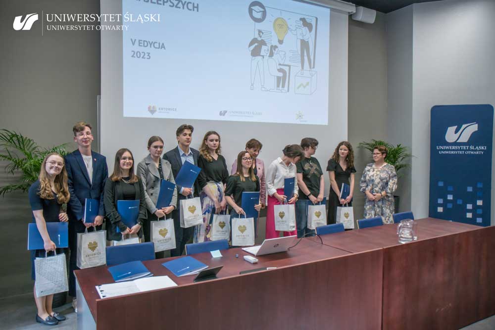 Laureaci V edycji Uniwersytetu Najlepszych. Młode osoby trzymają papierowe torby z nagrodami oraz dyplomy.